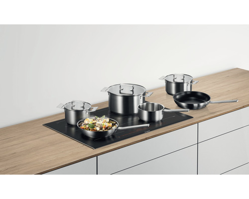 Topfset aus Edelstahl auf einem Induktionskochfeld auf einer Küchentheke