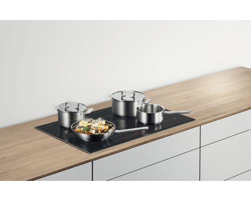 Plaque de cuisson avec casseroles et poêle sur un plan de travail de cuisine