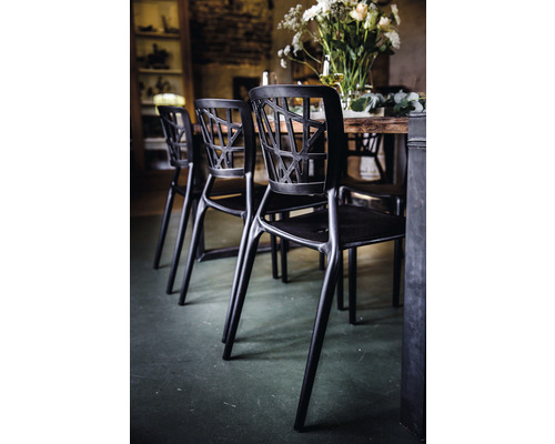 Chaise noire avec dossier ajouré près d''une table à manger