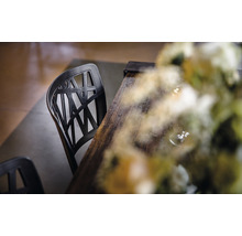 Chaise noire en plastique avec table en bois et décoration florale