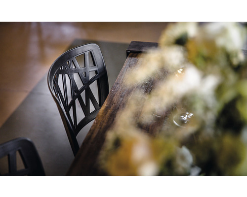 Chaise noire en plastique avec table en bois et décoration florale