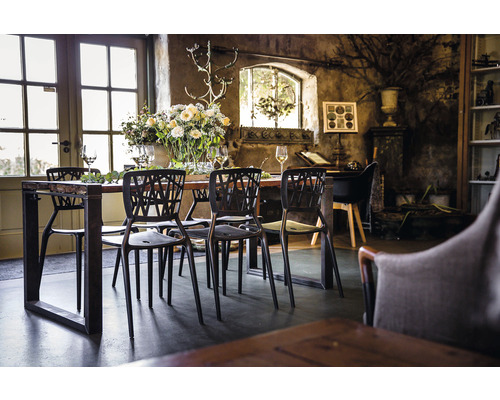 Table à manger avec chaises dans une pièce lumineuse avec décor rustique et fleurs