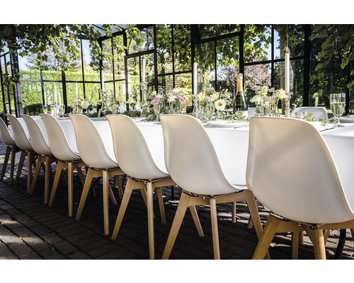 Table dressée de manière festive avec des chaises pour un événement en plein air.