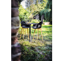 Scène de jardin avec petite table, deux tabourets de bar, verres à vin et décoration