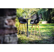 Scène de jardin avec une table de bar et deux tabourets de bar sur une pelouse.