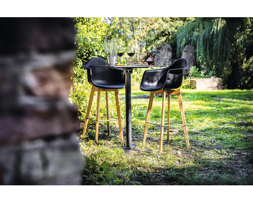 Scène de jardin avec une table de bar et deux tabourets de bar sur une pelouse.