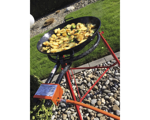 Paella-Pfanne auf Gasbrenner mit Kartoffeln und Gemüse im Freien.
