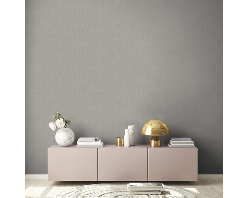 Wohnraum mit grauer Textiltapete, Kommode und dekorativen Elementen