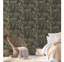 Schlafzimmer mit Dschungeltapete mit Tier- und Pflanzenmotiven, Bett und Korbsessel