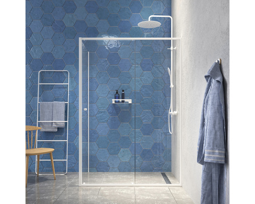 Modernes Badezimmer mit blauen, sechseckigen Fliesen, einer Duschkabine mit Glastüren und einer Handtuchleiter