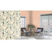 Wohnraum mit floral gemusterter Tapete, Sitzgelegenheiten und Zimmerpflanze.