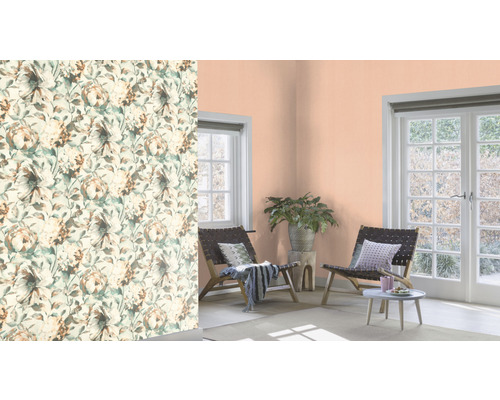 Wohnraum mit floral gemusterter Tapete, Sitzgelegenheiten und Zimmerpflanze.