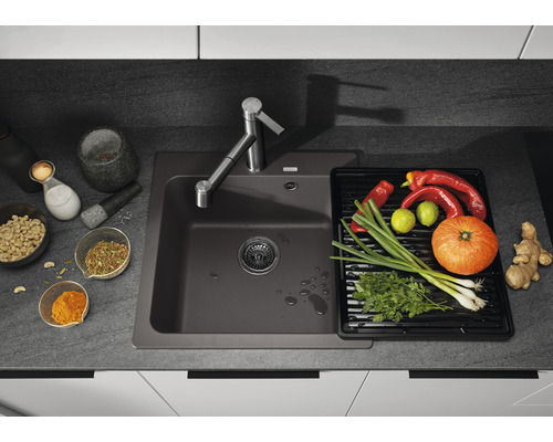 Küchenspüle aus Verbundmaterial mit Abtropffläche, Armatur und frischen Zutaten