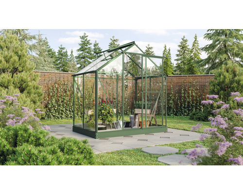 Gewächshaus Vitavia Triton 2500 Sicherheitsglas 3 mm 198 x 131 cm smaragd Gewächshaus mit Glaswänden in einem Garten mit Pflanzen und Bäumen.