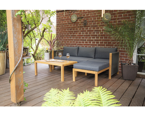 Gartenszene mit Lounge-Set, Tisch, Getränken und Pflanzen auf einer Terrasse