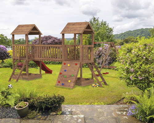 Aire de jeux pour enfants en bois avec balançoire, toboggan et mur d''escalade dans le jardin.