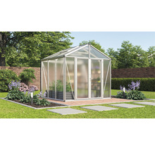 Gewächshaus im Garten mit Pflanzen und Gartenweg.