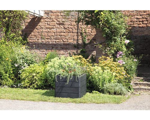 Jardinière carrée en plastique dans un jardin avec des fleurs