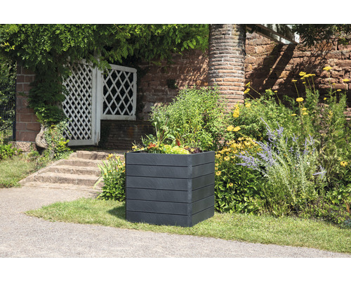 Jardinière carrée en plastique avec plantes dans le jardin.