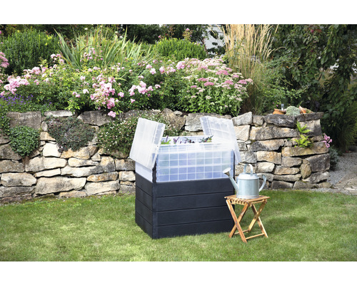 Jardinière surélevée avec couvercle de forçage et arrosoir dans le jardin