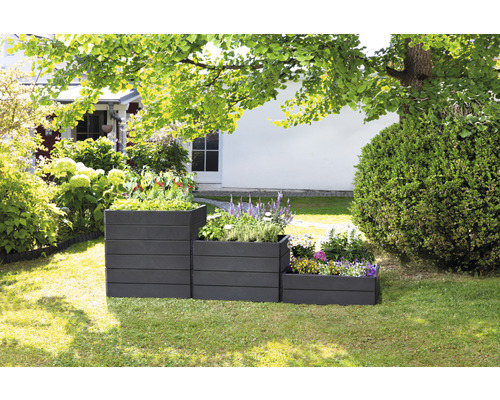 Bacs à fleurs en bois à trois niveaux dans le jardin avec des plantes