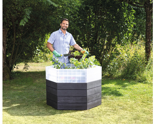 Jardinière surélevée en bois avec un homme jardinant dans le jardin
