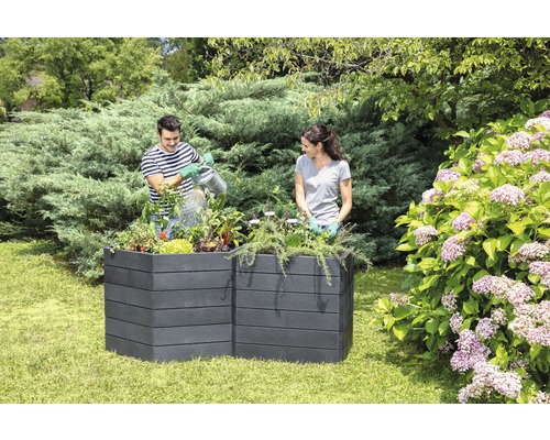 Deux personnes dans le jardin plantant un potager surélevé en plastique