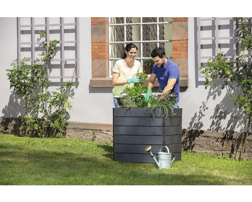 Scène avec un bac à fleurs et deux personnes plantant des plantes.