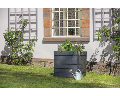 Jardinière carrée en bois avec arrosoir dans le jardin