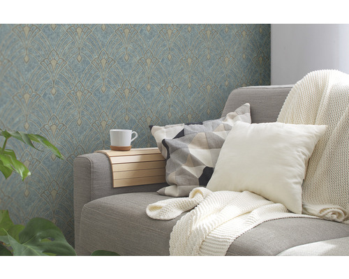 Wohnzimmer mit grauer Couch, Kissen, Decke, Beistelltisch mit Tasse und gemusterter Tapete