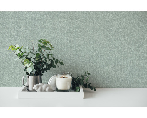 Scène décorative avec papier peint, bougie et plante sur une table