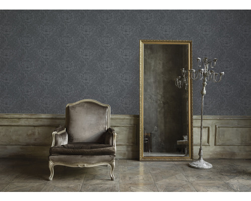 Salon avec papier peint à motifs floraux, fauteuil, miroir et chandelier