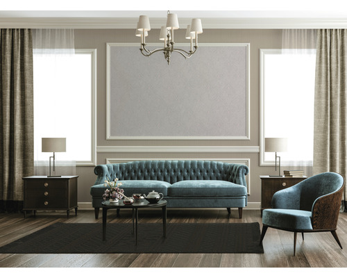 Wohnzimmer mit Sofa, Sessel, Teppich, Tisch und Dekoration