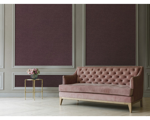 Zimmer mit strukturierten Tapeten, einem rosa Sofa und einem Beistelltisch mit Blumen