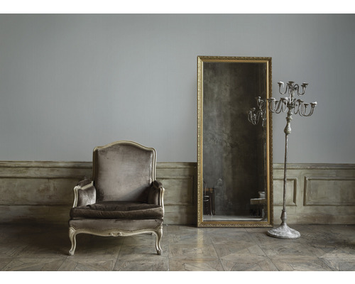 Fauteuil vintage, miroir et chandelier dans un intérieur