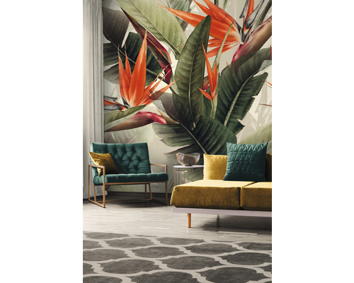 Salon avec papier peint à motifs floraux, fauteuil, canapé et tapis