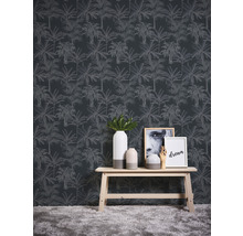 Szene mit einer Wandtapete mit Palmenmuster, einem Holztisch, Vasen und Dekorationsartikeln.