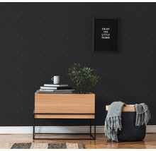 Raumansicht mit gemusterter Tapete, Holzkommode, Pflanze, Dekoration und Korb