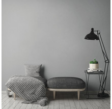 Wohnzimmerszene mit Sitzbank, Kissen, Decke, Stehlampe und Beistelltisch