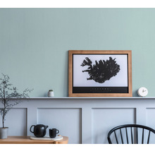 Dekorative Wohnszene mit Islandkarte im Rahmen, Teekanne und Zimmerpflanzen