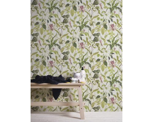 Wand mit botanischer Blumentapete, dekoriert mit Handtuch und Badprodukten auf einem Holztisch