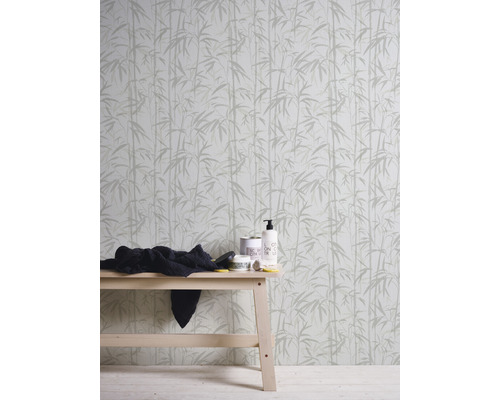 Tapete mit Bambusmuster hinter einem Holztisch mit Pflegeprodukten und einem Tuch