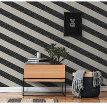 Wohnraum mit schräg gestreifter Tapete, Holzkommode, Pflanze, Dekoration und Korb