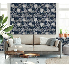 Salon avec canapé et papier peint à motif végétal