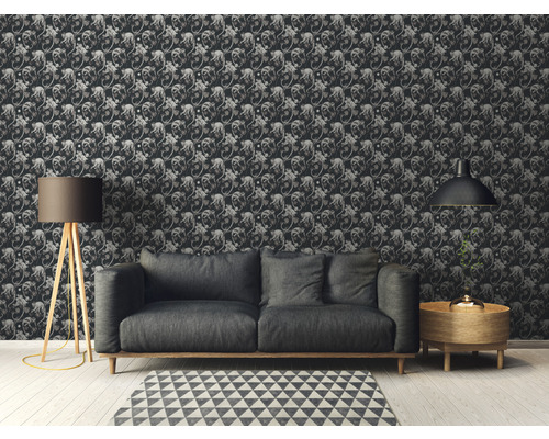 Dekoriertes Zimmer mit gemusterter Tapete, Sofa, Lampe und Beistelltisch