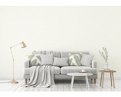 Wohnzimmer-Szene mit Sofa, Kissen, Decke, Lampe und Tisch