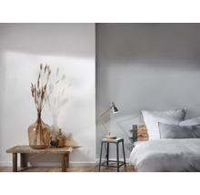 Helles Schlafzimmer mit Holztisch, Glasvasen und Bett