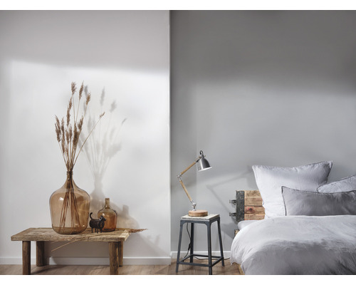 Helles Schlafzimmer mit Holztisch, Glasvasen und Bett