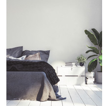 Schlafzimmer mit Bett, Nachttisch und Zimmerpflanzen