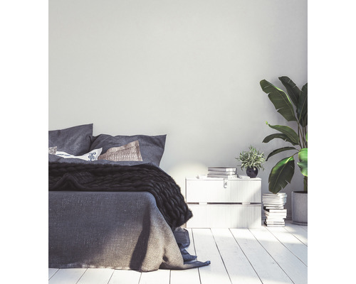 Schlafzimmer mit Bett, Nachttisch und Zimmerpflanzen